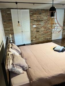 Saschiz2 Rooms Cozy Apartment at Harmony Farmhouse 444的一间卧室设有一张带砖墙的大床