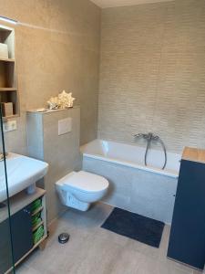 科特布斯Spree Chalet Cottbus的浴室配有卫生间、浴缸和水槽。