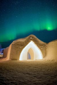 希内塔Arctic SnowHotel & Glass Igloos的星空下,有北极光的冰屋