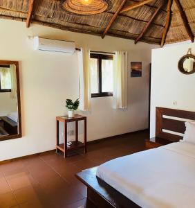 维兰库卢什Mangal Beach Lodge的一间卧室配有一张床和镜子