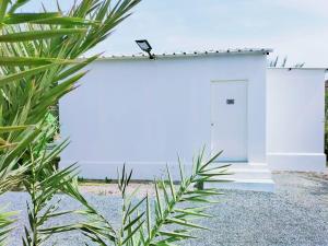 富查伊拉The Palm Estate的白色的建筑,在海滩上有一扇门