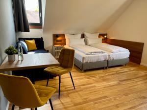 魏斯基兴JUNIPRO Hotel Schinderhannes的卧室配有一张床和一张桌子及椅子