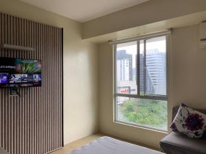 宿务Comfy Avida Cebu w/ Pool(2 adjoined units) 50MBPS的一间卧室设有一张床和一个大窗户
