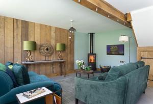 DowntonThe Timber Barn的客厅设有蓝色的沙发和壁炉