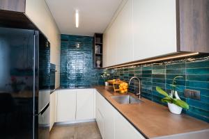 杜布罗夫尼克Luxury Apartment Libertas的厨房配有白色橱柜和蓝色瓷砖