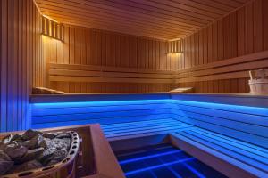 格丁尼亚My Story Gdynia Hotel的木制客房内的蓝色灯光浴缸