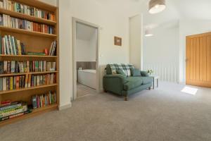 奥顿Linden Barn的客厅配有沙发和带书籍的书架
