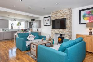 卡莱尔Stunning 1-Bed Cottage near Carlisle with Hot tub的客厅配有2把蓝色椅子和壁炉