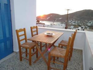 伊奥斯乔拉Vasilis Place Ιos的阳台上配有一张木桌和四把椅子