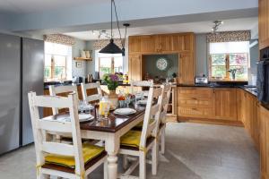RadcotRadcot Bridge Cottage的厨房以及带木桌和椅子的用餐室。