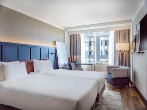 斯德哥尔摩斯德哥尔摩水滨丽笙酒店的酒店客房,配有两张床和椅子