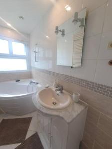 普瓦捷Maison à Poitiers - Futuroscope的白色的浴室设有水槽和浴缸。