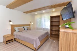 帕兰加SMILTIS的一间卧室配有一张床和一台平面电视