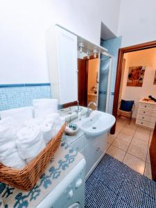 福洛尼卡Puzzle al Mare的一间带水槽和一篮毛巾的浴室