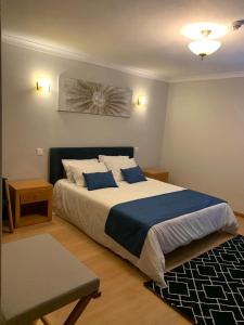 圣孔巴当AL Restaurante A Lampreia的一间卧室配有一张带蓝白色床单的大床