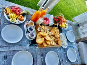 巴尼亚Alpina Luxury Chalets的野餐桌,盘子上放着食物和盘子