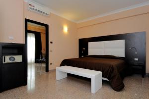 菲乌米奇诺EH Rome Airport Euro House Hotels的一间卧室设有一张大床和一张白色长凳