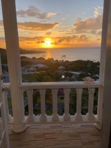 CanouanAtlantic Breeze Apartments, Canouan Island的从房子的阳台上可欣赏到日落美景