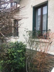 Deuil-la-BarreÔ Cottage - Maison d'hôtes proche Paris à 20 minutes的一座有窗户的建筑,前面有植物