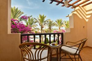 马萨阿拉姆Dream Lagoon Resort & Aqua Park的阳台配有桌椅和棕榈树。