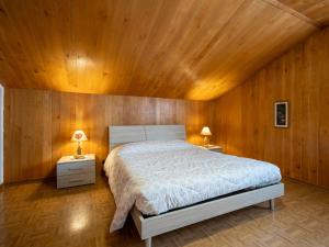 SarreApartment Marmotte by Interhome的一间卧室配有一张带木墙的大床