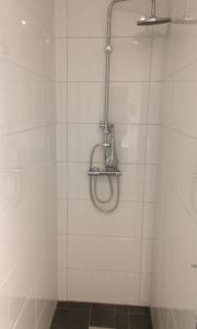 阿姆斯特丹阿姆斯特丹旅馆的浴室设有白色瓷砖墙壁和淋浴。