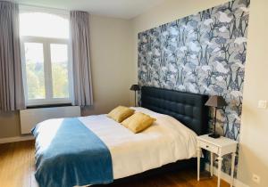 特纳维耶L'Aubier的一间卧室配有一张带蓝白色毯子的床