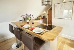 South StokeThe Loft的厨房配有木桌、椅子和酒杯