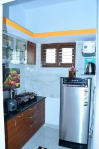 迈索尔Kailash Guest Home的厨房配有炉灶和冰箱。