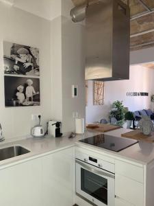 塔拉戈纳Fantastico Tarragona Corsini Apartment-1, en el centro con parking的白色的厨房设有水槽和炉灶。