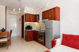 斯卡拉伯塔麦斯Villa Panorama的厨房配有木制橱柜和白色冰箱。