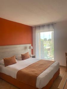 利勒鲁斯海滨喷泉酒店的一间卧室设有一张大床和大窗户
