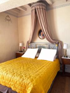 FreignéManoir de Ghaisne的一间卧室配有一张带天蓬的黄色床