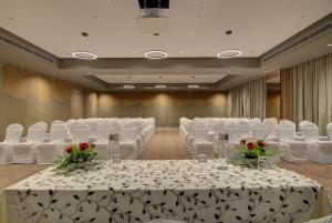 斋浦尔7 Apple Hotel Pratap Nagar, Jaipur的宴会厅配有白色的桌椅和鲜花