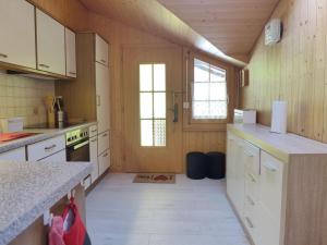 NiederriedApartment Chalet Vamika by Interhome的厨房设有木墙和白色橱柜。