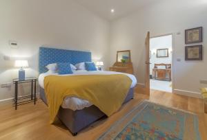 HoxneDownbridge Lodge的一间卧室配有一张带黄色毯子的大床
