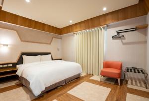 竹北The Cloud Hotel的一间卧室配有一张床和一张红色椅子