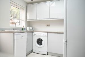 什鲁斯伯里Rose Cottage的白色洗衣房配有洗衣机和烘干机