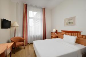 杰尔Danubius Hotel Raba的酒店客房设有白色的床和窗户。