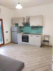 卡斯塔涅托卡尔杜奇Mini appartamento in campagna的厨房配有白色橱柜和炉灶烤箱。