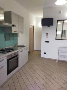 卡斯塔涅托卡尔杜奇Mini appartamento in campagna的厨房配有白色橱柜和炉灶烤箱。