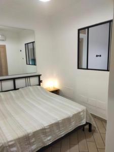 卡斯塔涅托卡尔杜奇Mini appartamento in campagna的白色卧室配有床和镜子
