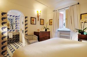 波西塔诺勒西雷纳斯酒店的卧室配有白色的床和窗户。