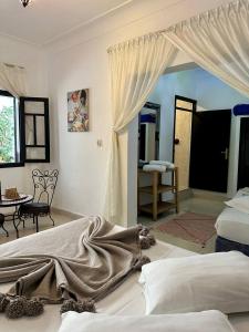 马拉喀什伊尔肯纳利亚酒店的一间卧室配有一张床,另一间卧室配有桌子