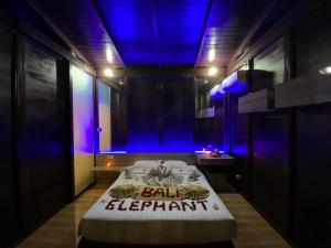 金巴兰巴厘岛大象精品别墅酒店的一间设有蓝色灯光的床的房间