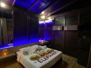金巴兰巴厘岛大象精品别墅酒店的一间设有蓝色灯光的床的房间
