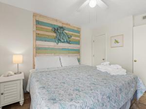 默特尔比奇Sand Dollar, Unit 103的一间卧室配有一张带木制床头板的床
