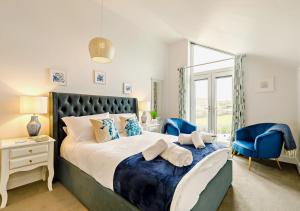 圣艾夫斯Coastal Dreams的一间卧室配有一张大床和蓝色的椅子