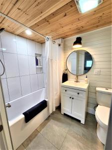特拉弗斯城Exclusive 2 Chalet Stay-HotTub-Fireplace-Beachside的带浴缸、盥洗盆和卫生间的浴室