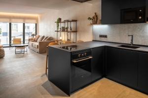 大加那利岛拉斯帕尔马斯TocToc Suites Olof Palme的配有黑色家电的厨房和客厅